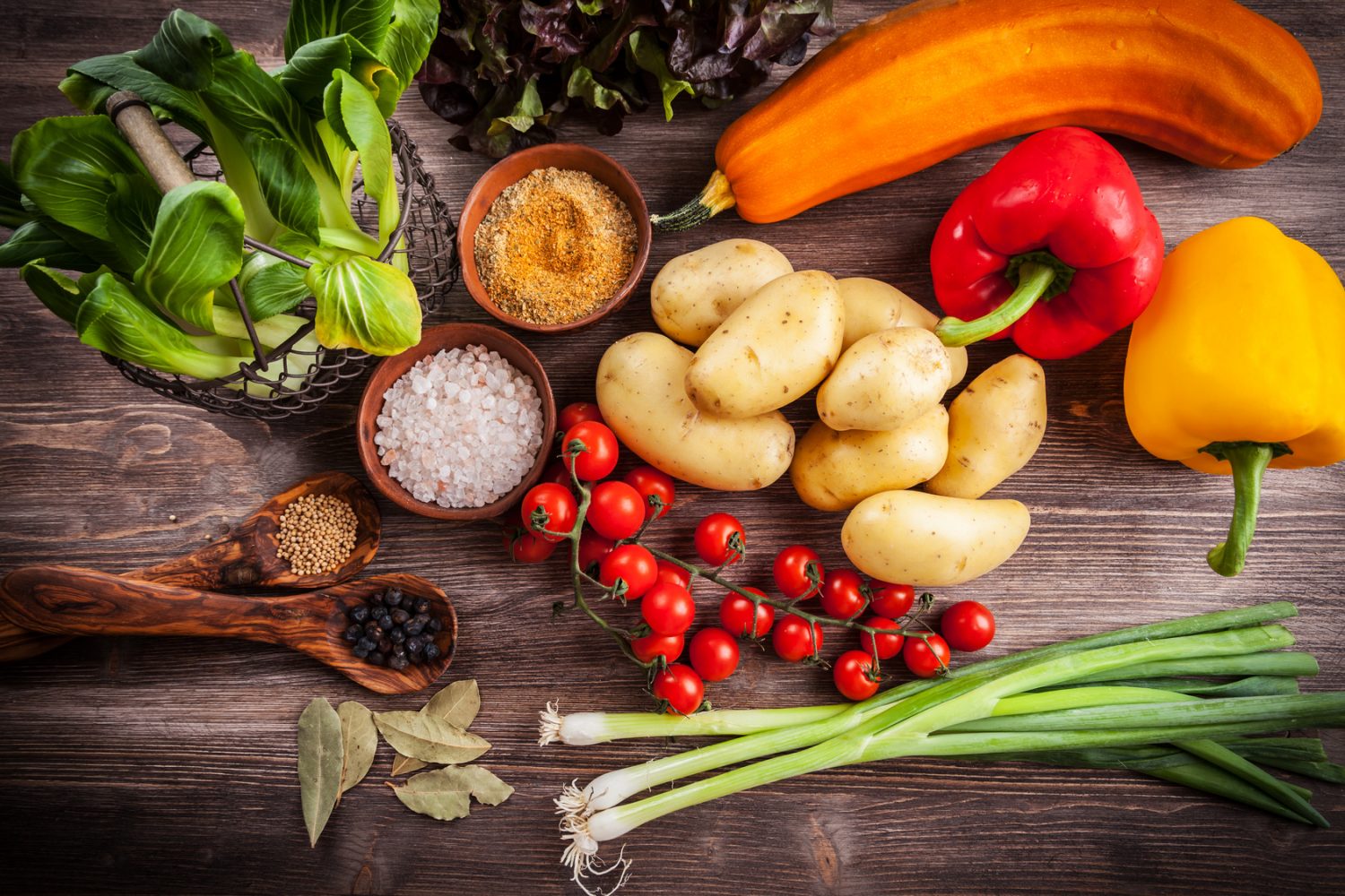 Raw vegetables with spices on wooden table