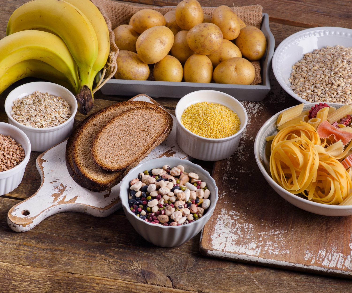 Foods high in carbohydrate on rustic wooden background. Top view